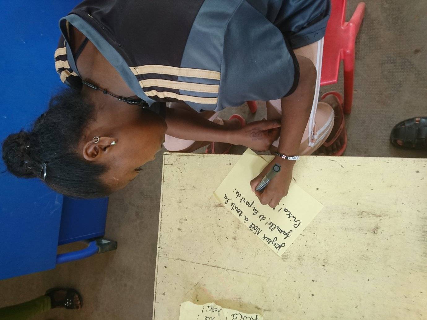 Prisca écrit à un message pour son parrain