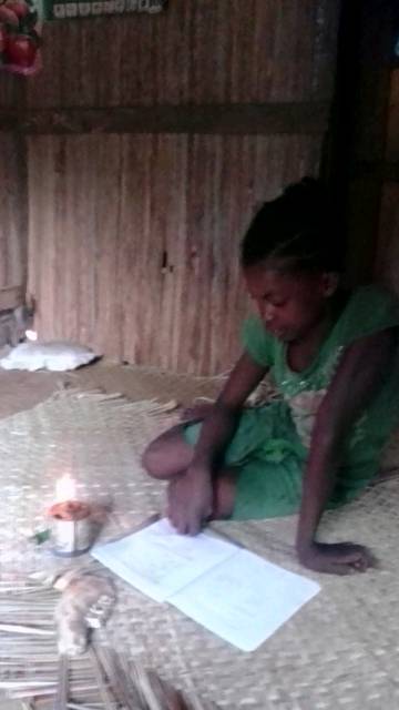 Christine fait ses devoirs avec une lampe de pétrole